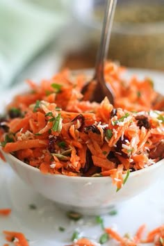 a white bowl filled with carrot salad on top of a table