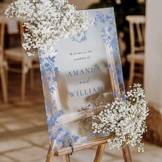 an easel with baby's breath flowers on it and a wedding program in the background