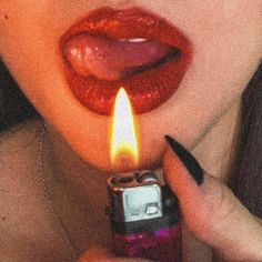 a woman holding a lighter in front of her face with lipstick on it's lips