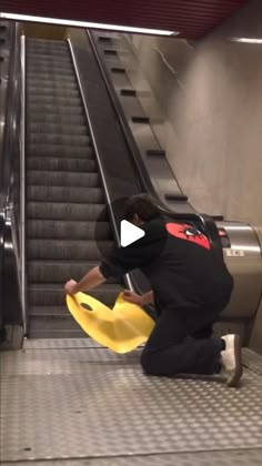 a person kneeling down on an escalator with a yellow frisbee