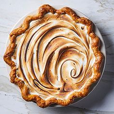 a white plate topped with a pie covered in frosting