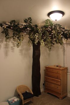 a room with a tree and dresser in it