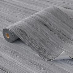 a roll of grey woodgrain paper on the floor