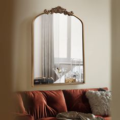 a living room filled with furniture and a large mirror on the wall above it's headboard