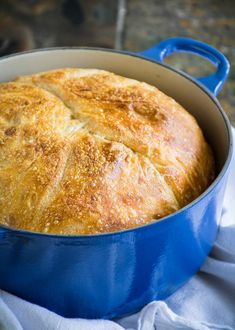 a blue pot filled with bread on top of a white cloth