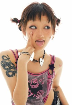 a woman with tattoos making a funny face while holding her hand to her mouth and looking at the camera