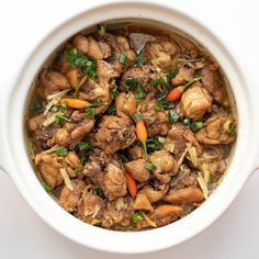 a white bowl filled with meat and vegetables