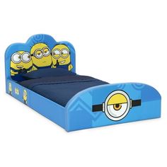 a blue bed with three yellow minion faces on the headboard and foot board