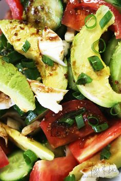 a salad with tomatoes, avocado and other vegetables