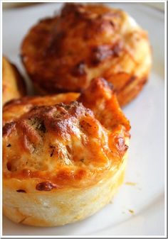 three mini quiches on a white plate, one has cheese and the other has meat