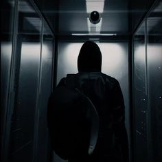 a person in a dark room with a backpack