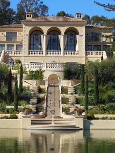 a large house with a fountain in front of it