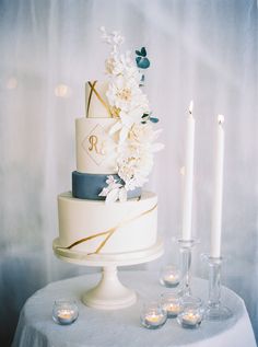 a wedding cake with flowers and candles on a table