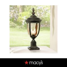 an old fashioned lamp is on display in front of a window with the words macy's written below it