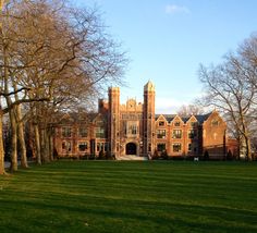 an old brick building surrounded by trees and grass