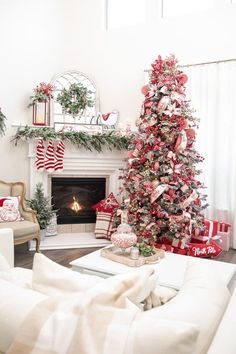 a living room with a christmas tree in the corner and stockings on the fireplace mantel