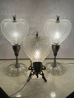 three glass lamps sitting on top of a table