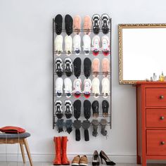 there are many pairs of shoes hanging on the wall next to a dresser and mirror