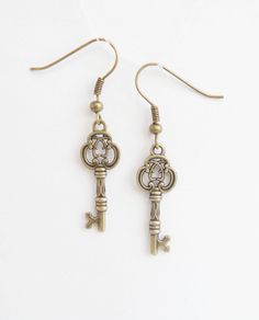 Bronze Key Earrings   Earrings are made using antiqued bronze . The vintage style ornate skeleton keys dangle from tiny but detailed infinity knots which are attached to bronze effect french earwires for pierced ears. They are reasonably small and suitable for everyday wear. I wear my own pair quite a lot as they go with pretty much anything vintage style. length - 3,5 cm Earrings: https://www.etsy.com/shop/NewJewelleryStory?ref=seller-platform-mcnav&section_id=17110923 Stud earrings: https://ww Key Earrings Aesthetic, Skeleton Key Earrings, Antique Earrings Studs, Skeleton Key Jewelry, Key Earrings, Large Gift Boxes, Skeleton Keys, Earrings Aesthetic, Vintage Key