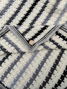 a black and white blanket with a button on it