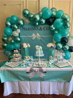 a table topped with lots of blue and green balloons