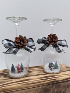 two wine glasses with christmas decorations in them