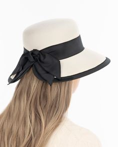 A women’s fall felt hat, trimmed with grosgrain that is timeless and chic. This is a special occasion style, not to be worn casually, which adds grace and presence. Viewed from the front, the dressy silhouette reminds one of Audrey Hepburn’s hats; a medium size brim curves gently downward .The unexpected surprise feature is the cutaway tulip shape of the brim in back, which finishes in a feminine double bow. UPF 50+ Blocks 98% UVA/UVB rays Hand blocked Elasticized inner band for comfortable fit