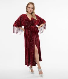 Wrap yourself in velvet, dears! This marvelous wrap dress from Unique Vintage is crafted in a gorgeous burgundy fabric that features a stunning silver star accent throughout. The sultry wrap design is secured with dual buttons creating a surplice neckline that is framed by dolman sleeves with attached fringe. The seamed high waist is cinched by a self tie sash while the skirt cascades to a sweeping midi silhouette!.Available in sizes XS-5X while supplies last. | Unique Vintage 1970S Burgundy Vel Velvet Dress With Boots, Orange Velvet Dress, 70s Fashion Women, 70s Velvet, Burgundy Fabric, Wardrobe Wishlist, Velvet Clothes, Orange Velvet, Burgundy Velvet