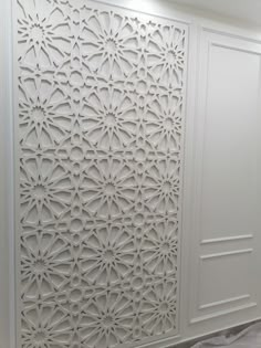 a white room divider with an intricate design on the front and back paneling