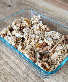 a glass dish filled with granola on top of a wooden table