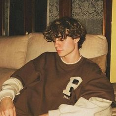 a young man sitting on top of a couch