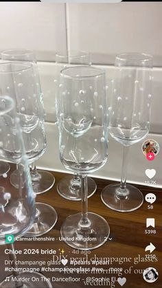 four wine glasses sitting on top of each other in front of a tile backsplash