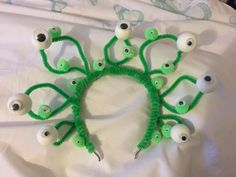 a group of fake eyeballs on top of a white sheet covered in green yarn