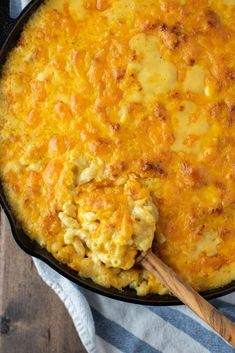 a skillet filled with macaroni and cheese on top of a blue and white towel