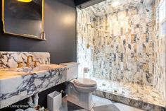 a bathroom with marble counter tops and walls