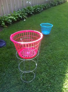 two blue and pink baskets sitting in the grass