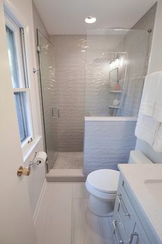 a white toilet sitting next to a walk in shower