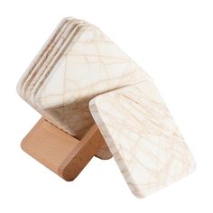 marble coasters stacked on top of each other in front of a white background and wooden stand