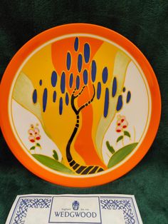 an orange and blue plate with a tree on it