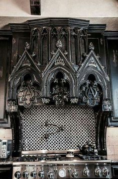 an old fashioned stove and oven in a kitchen with black cabinets, patterned backsplash