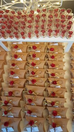 there are many wine glasses with red flowers in them on the shelf next to each other