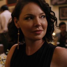 a woman in a black dress sitting at a table