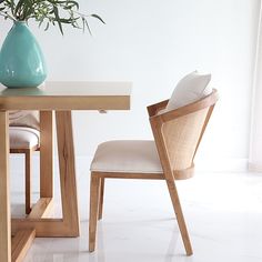 a wooden table with a vase on top of it and two chairs next to it