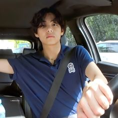 a young man sitting in the back seat of a car