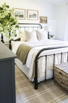 a bedroom with white bedding and green plants on the nightstands in front of the bed