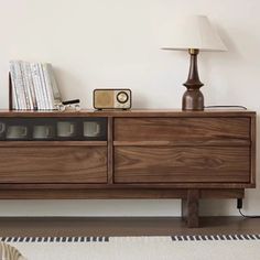 a wooden entertainment center sitting on top of a hard wood floor next to a lamp