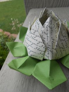 an origami flower sitting on top of green paper