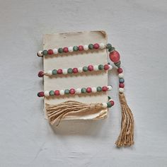 a piece of paper with beads and tassels hanging from it's side