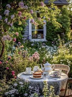 a table that has some food on it in the middle of flowers and plants around it