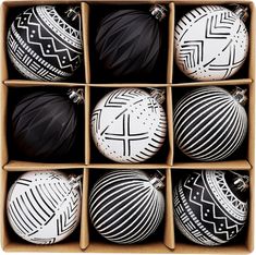 six black and white ornaments in a cardboard box